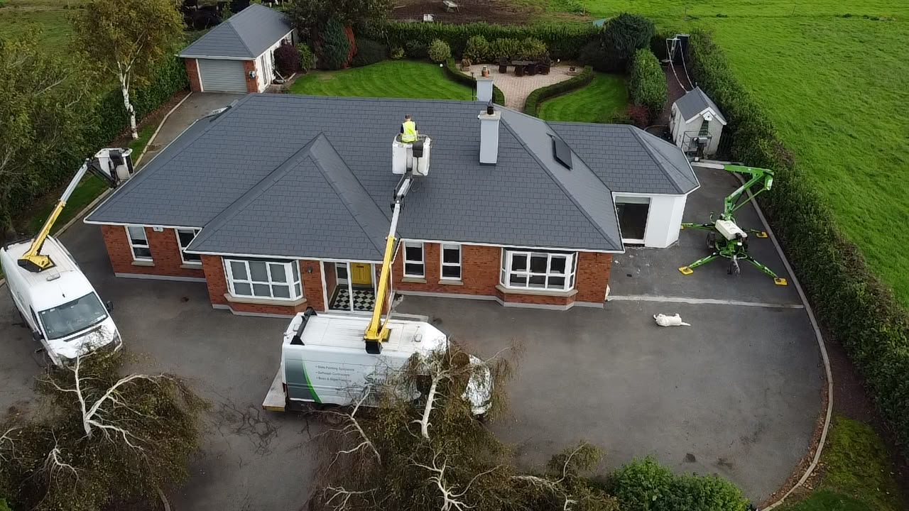 Drone view of Brian Kelly Services mechanical hoists re-coating a slate roof