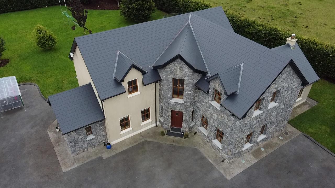 Drone view of a stone house with a freshly re-coated slate roof by Brian Kelly Services